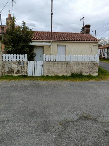 une clôture blanche devant une maison dans l'établissement maison dans hameau 6 km de la mer, à Pornic