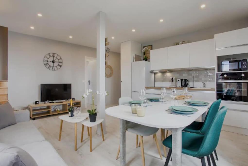 uma cozinha e sala de jantar com uma mesa branca e cadeiras em Mermoz/Deauville : Superbe Appartement em Deauville