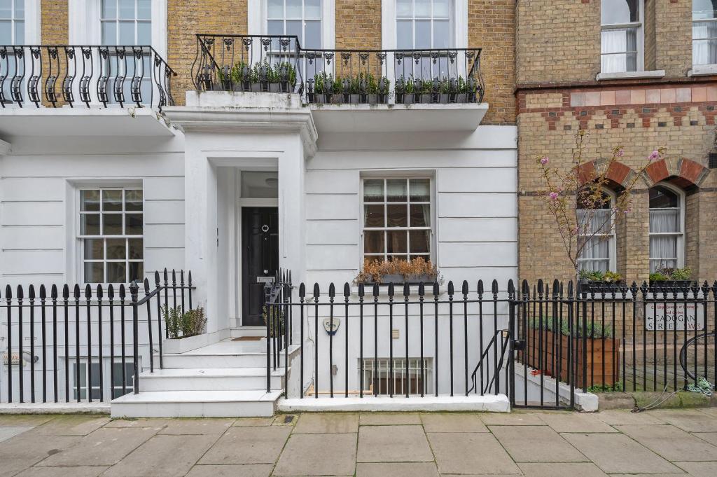 une maison blanche avec une clôture noire dans l'établissement Casa Italia near Sloane Square - AC all Bedrooms, à Londres