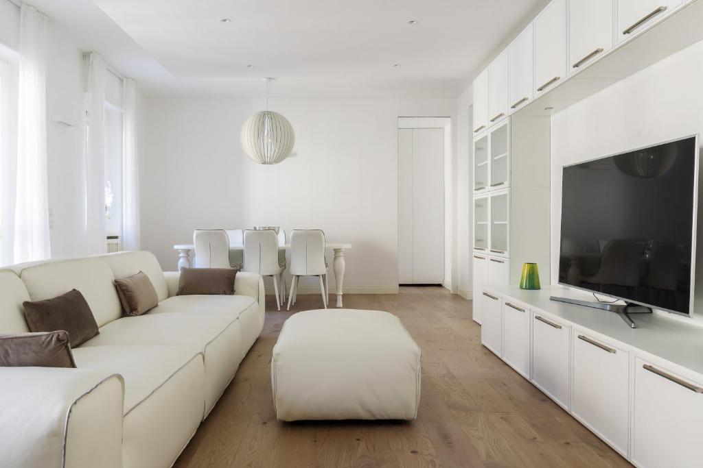 een witte woonkamer met een witte bank en een tv bij Pure White - by MyHomeInComo in Como