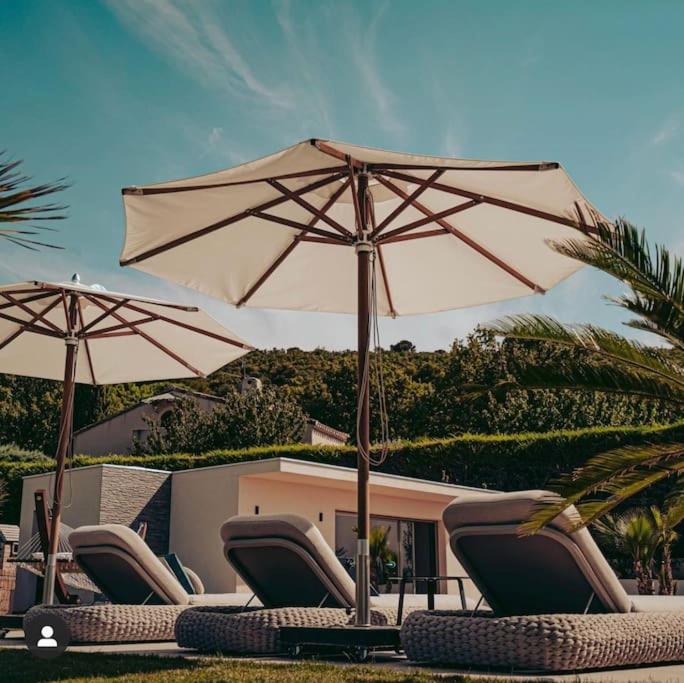 - un groupe de chaises longues et de parasols sur une plage dans l'établissement La Villa Sainte-Victoire / Luxury villa south of France, à Mimet