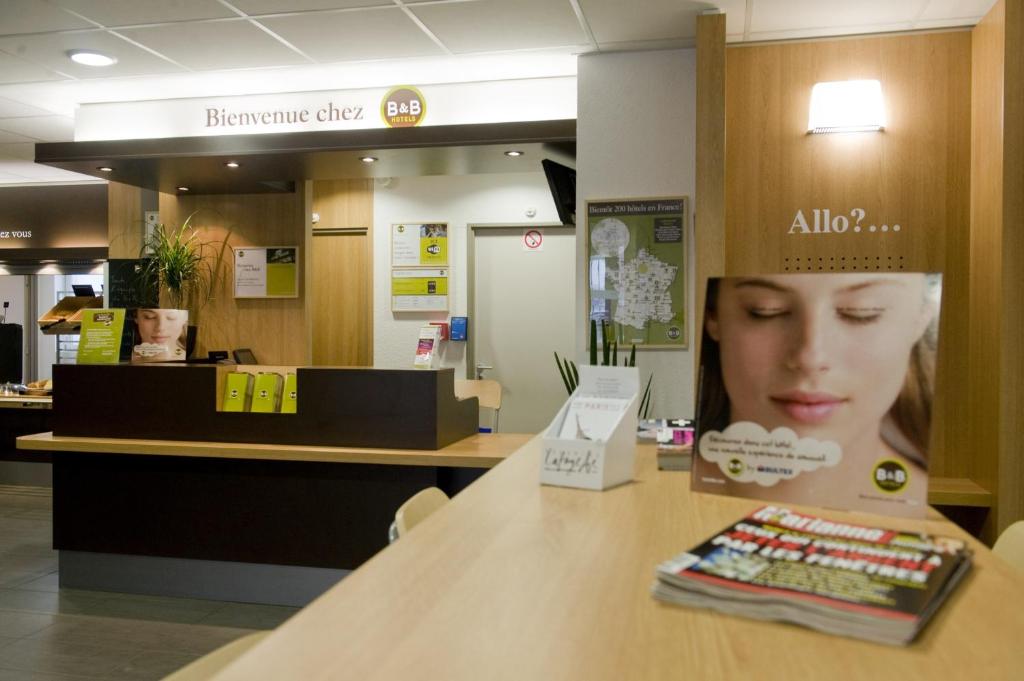 a counter in a store with a sign on a table at B&B HOTEL Paris Le Bourget in Le Bourget