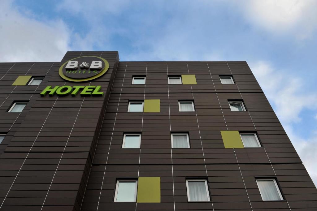 a building with a hotel sign on top of it at B&B HOTEL Paris Le Bourget in Le Bourget