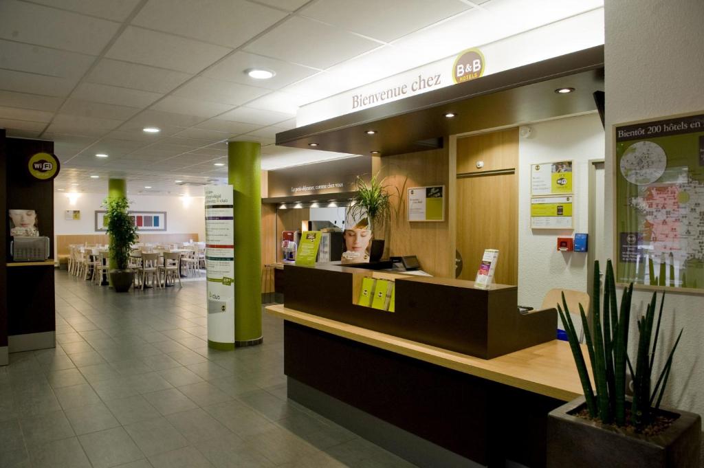 a restaurant with a counter in the middle of a building at B&B HOTEL Paris Le Bourget in Le Bourget