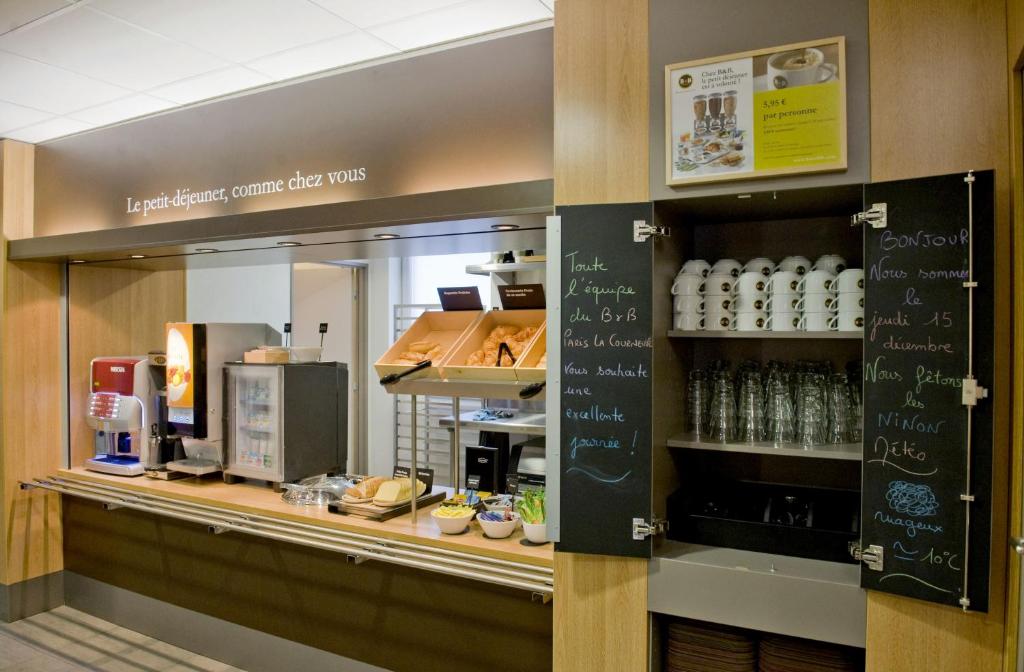 a kitchen with a counter with a coffee shop at B&B HOTEL Paris Le Bourget in Le Bourget