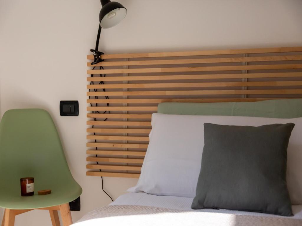 een slaapkamer met een bed en een groene stoel bij The Best Rent - Corso Buenos Aires Apartment in Milaan