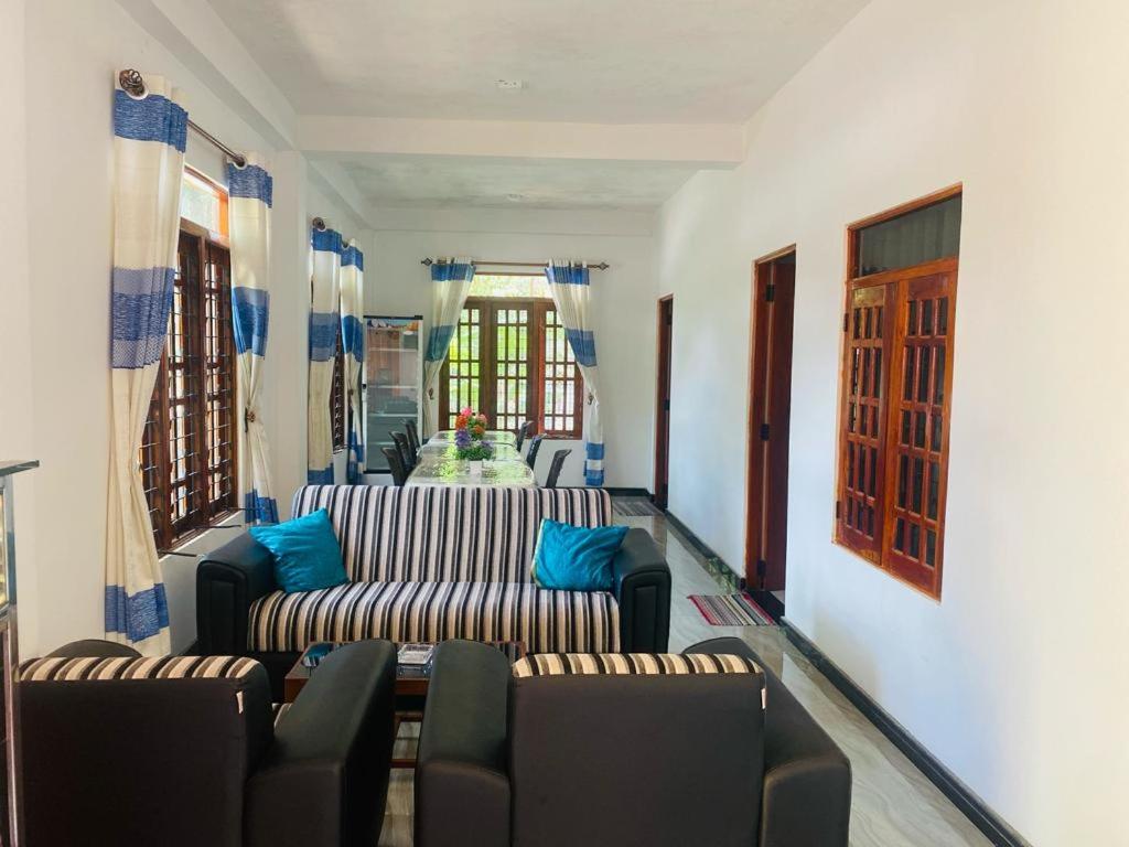 uma sala de estar com 2 sofás e almofadas azuis em Hotel Randiya em Nallathanniya