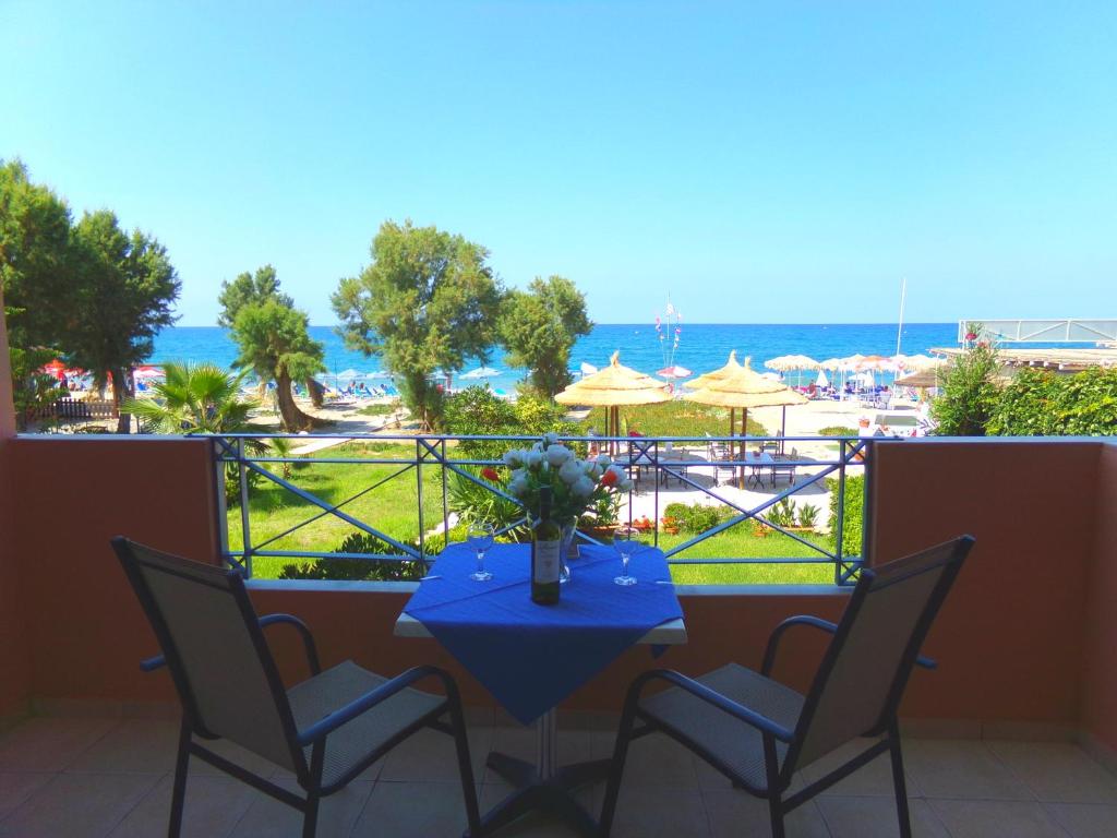 einen Tisch und Stühle auf einem Balkon mit Meerblick in der Unterkunft Katerina Seaside Studios in Platanias