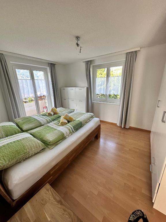 sypialnia z dużym łóżkiem i 2 oknami w obiekcie Wohnung Christania 3200 Unterbäch Wallis w mieście Unterbäch