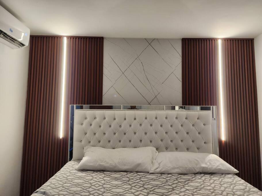 - une chambre avec un grand lit et une grande tête de lit dans l'établissement Luxury apartment and very quiet great area / Vacation Rental, à Santiago de los Caballeros