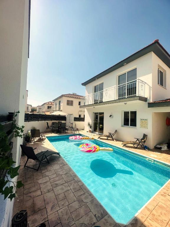 a swimming pool in front of a house at Athena Villa in Larnaka