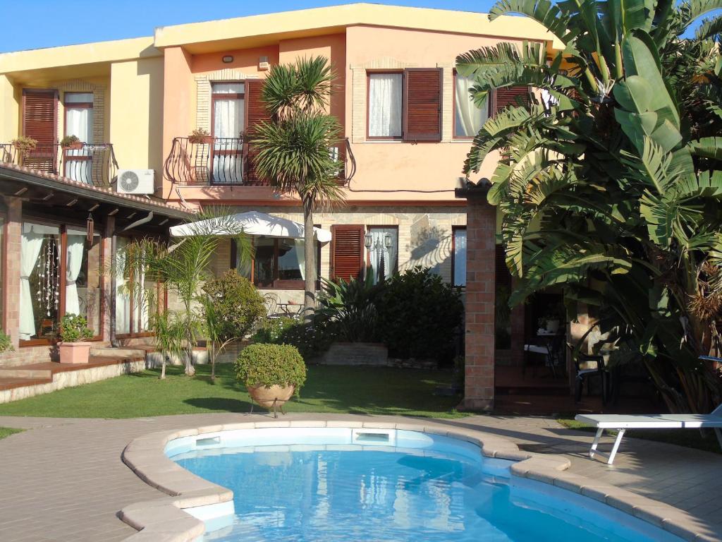 una casa con piscina delante de una casa en Villa Graziosa, en Quartu SantʼElena