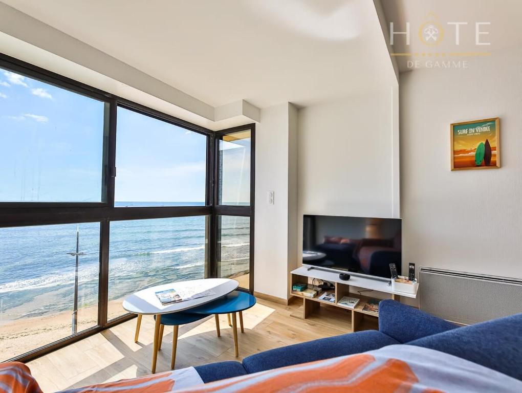 uma sala de estar com vista para o oceano em Appartement au pied de la plage, vue imprenable sur la mer em Les Sables-dʼOlonne