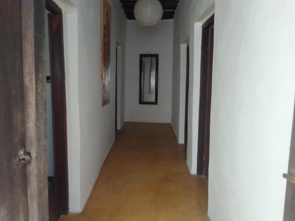 an empty hallway with white walls and a hallwayngth at Subira Guest House in Lamu