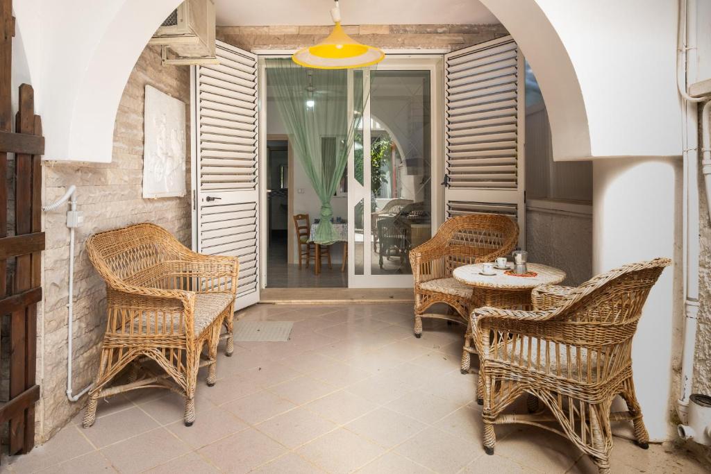 a patio with wicker chairs and a table and a window at Villa Ada Depandance 1 in Punta Prosciutto