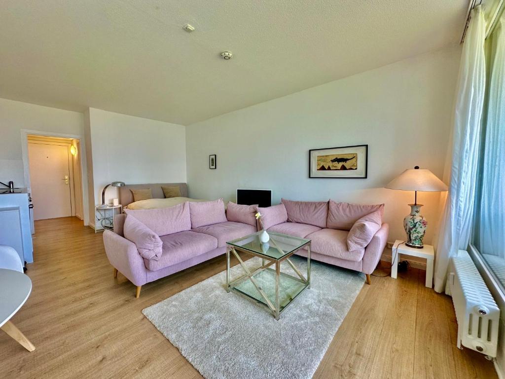 ein Wohnzimmer mit einem lila Sofa und einem Tisch in der Unterkunft Appartement mit traumhaftem Kieler Förde Blick in Kiel