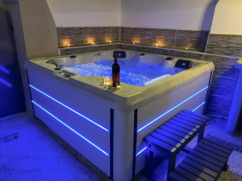 a hot tub with a bottle of wine in it at La Casa di villagio in Koskinou