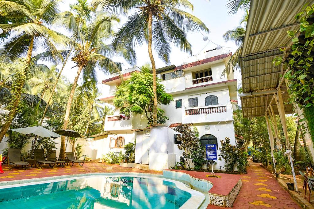 a house with a swimming pool in front of a building at Goa Divine Candolim in Calangute