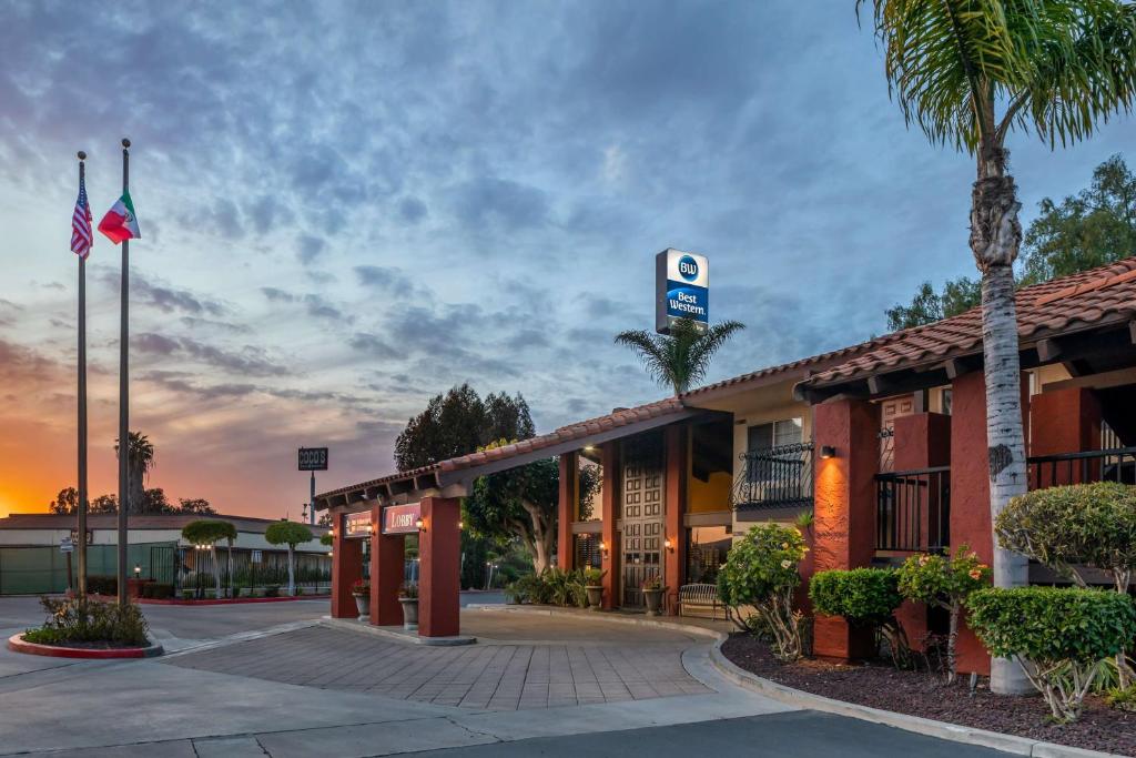 a hotel with a palm tree in front of a building at Best Western Americana Inn in San Ysidro, San Diego