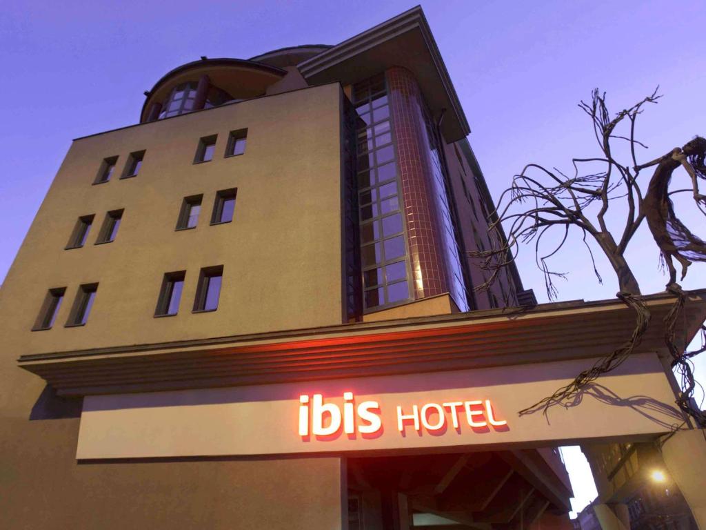 a building with a hotel sign in front of it at Ibis Budapest Heroes Square in Budapest