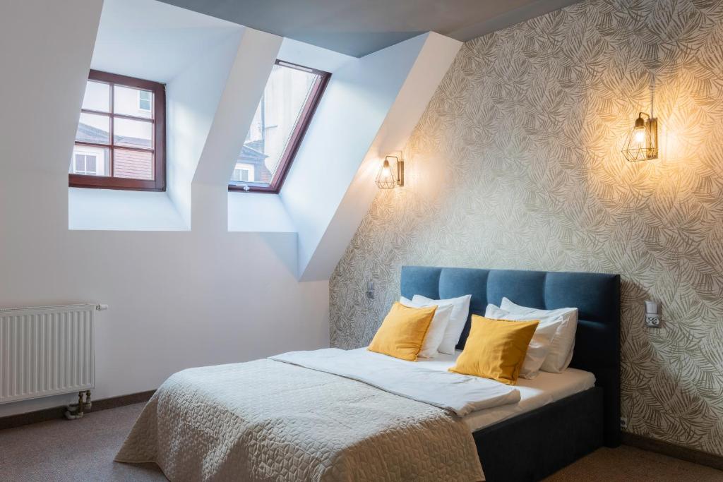 a bedroom with a blue bed with yellow pillows at Staycity Apartments Sukiennice 6 in Wrocław