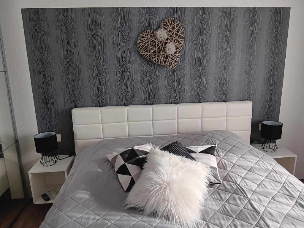 Freudental的住宿－Ferienwohnung Hofmann，卧室配有带白色棉被和枕头的床
