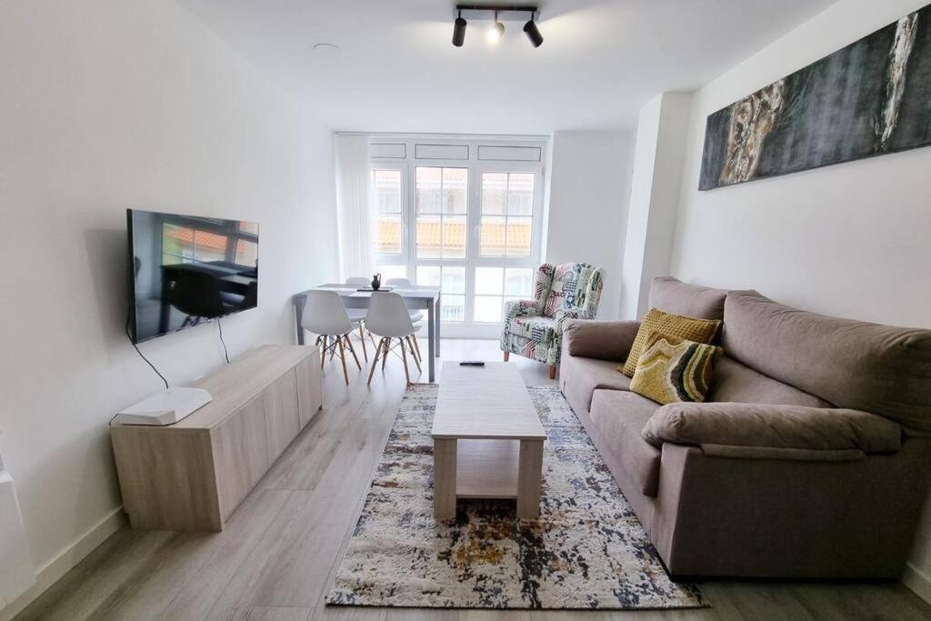 a living room with a couch and a table at VibesMalpica - Canido 12 in Malpica