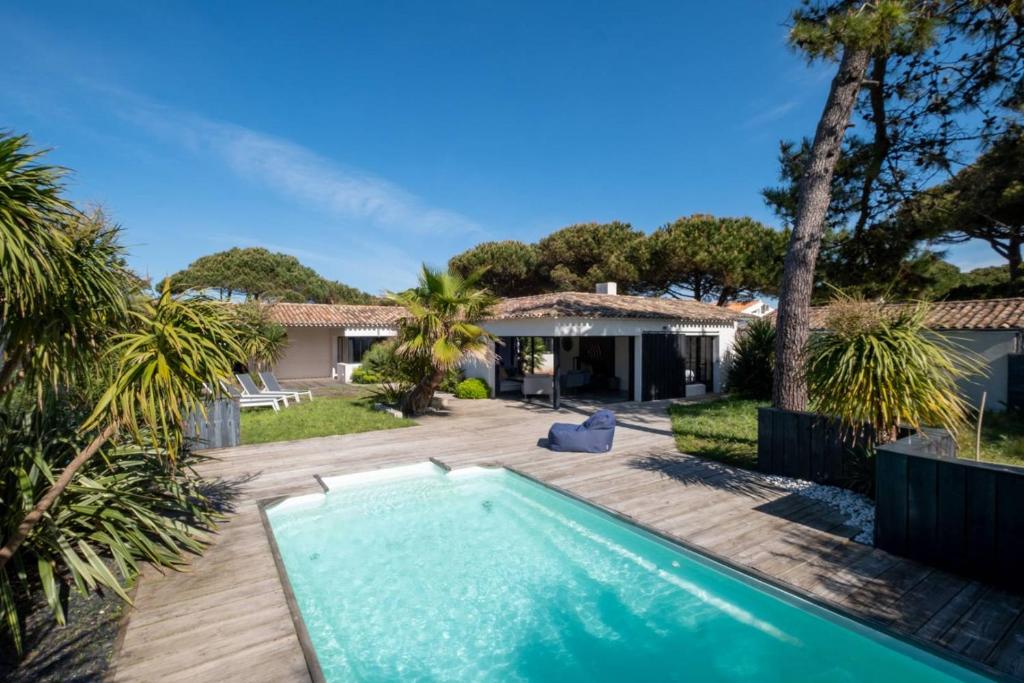 a swimming pool in the yard of a house at BEACH HOUSE in Les Grenettes