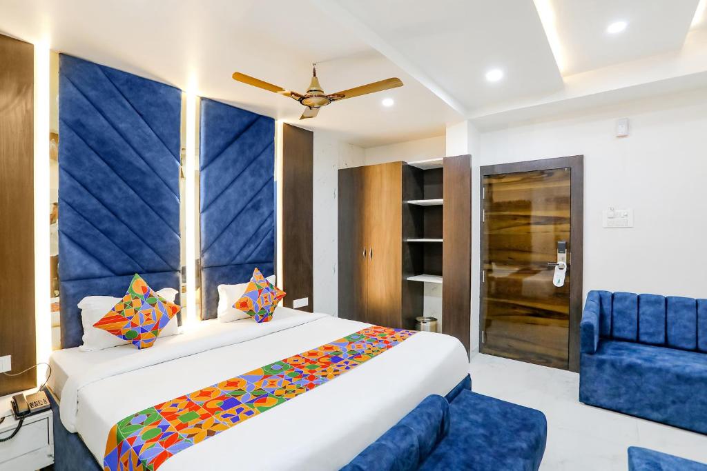 a bedroom with a large bed and a blue couch at FabHotel Prime SM Resort in Bhopal