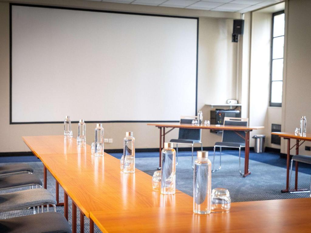 une salle de conférence avec une longue table et des lunettes dans l&#39;établissement Hôtel Mercure Rochefort La Corderie Royale, à Rochefort