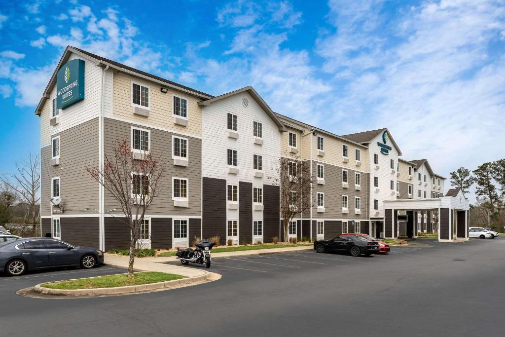 a large hotel with cars parked in a parking lot at WoodSpring Suites Macon North in Macon