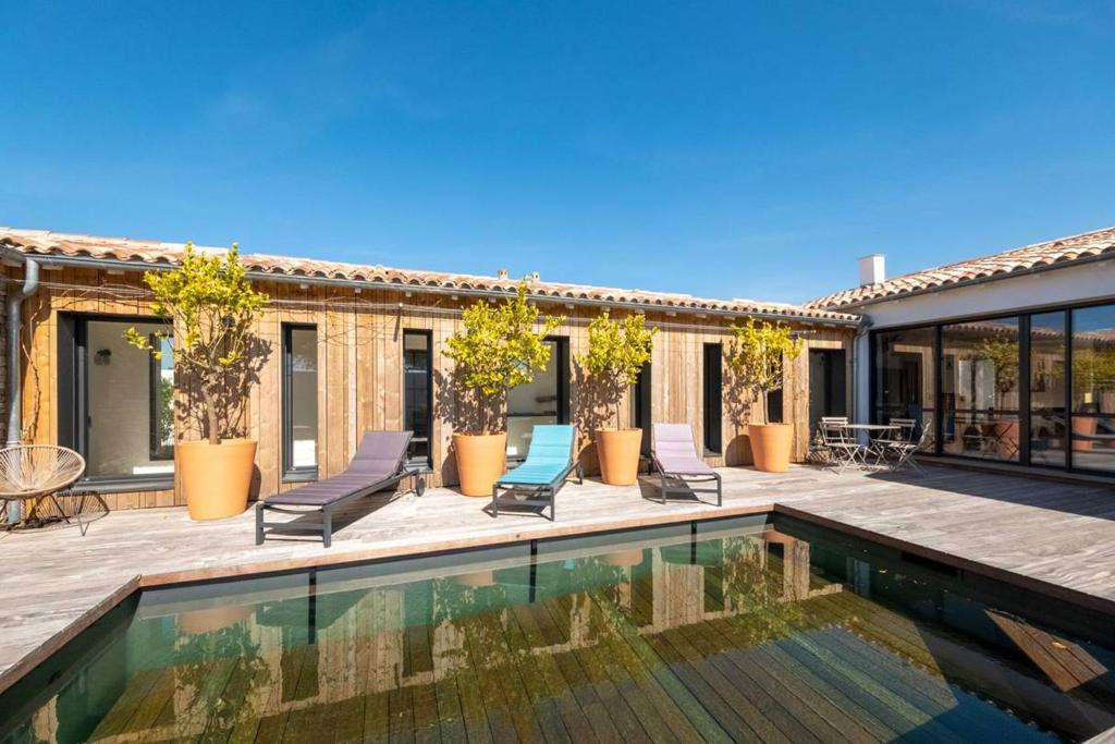 ein Bild von einem Haus mit einem Swimmingpool in der Unterkunft Maison neuve à deux pas de la plage in Sainte-Marie-de-Ré