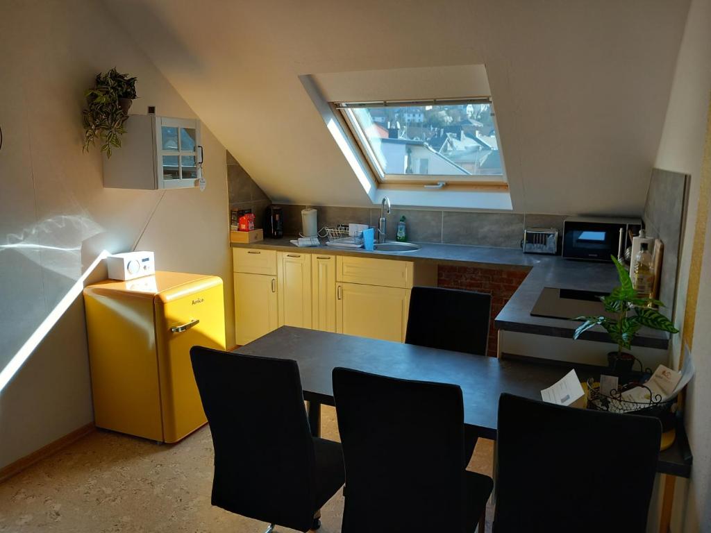 uma cozinha com mesa e cadeiras num quarto em Ferienwohnung im roten Haus em Bad Ems