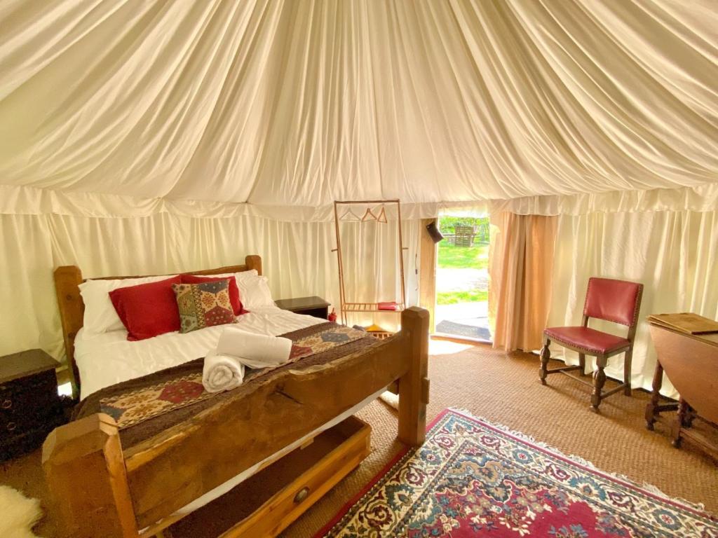 a bedroom with a bed in a tent at Elessar Yurt Village in Hawkley