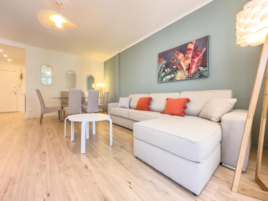 un salon avec un canapé et une table dans l'établissement Le Palm by Winsome Destination, à Cannes