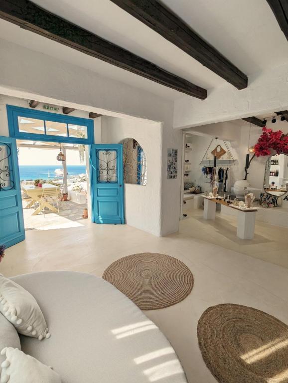 Ein Wohnzimmer mit blauen Türen und Meerblick in der Unterkunft Camares in Alopronia
