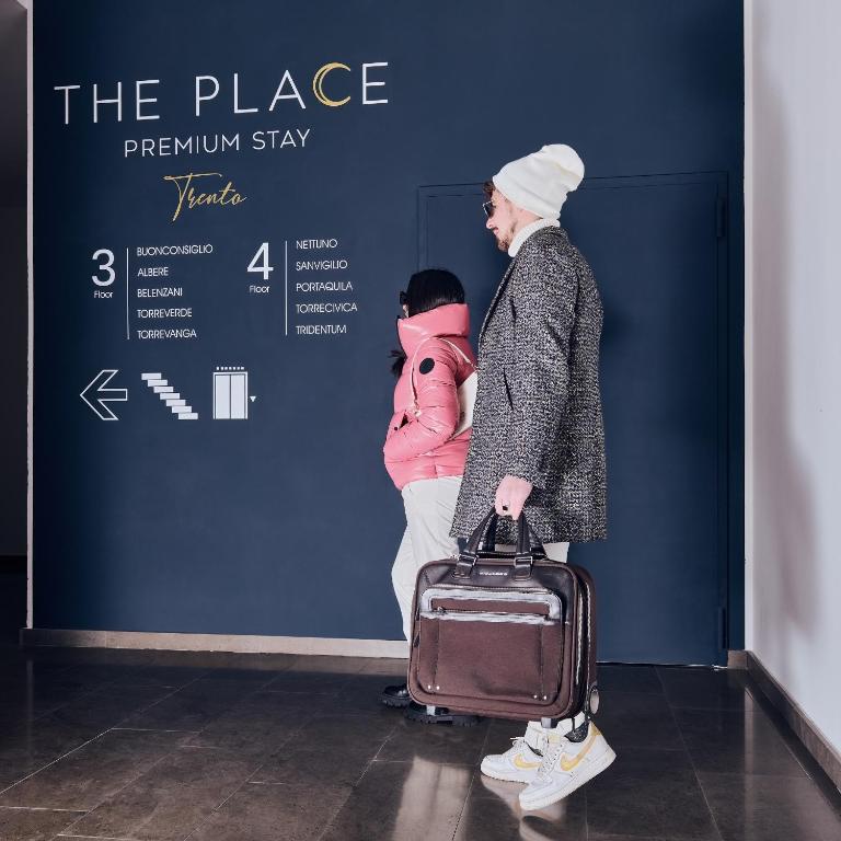 a man holding a suitcase next to a person with a suitcase at The Place - Only Self Check-in - No Reception in Trento