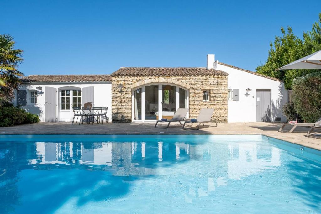a villa with a swimming pool in front of a house at Sublime maison d'architecte pour famille nombreuse in Les Portes