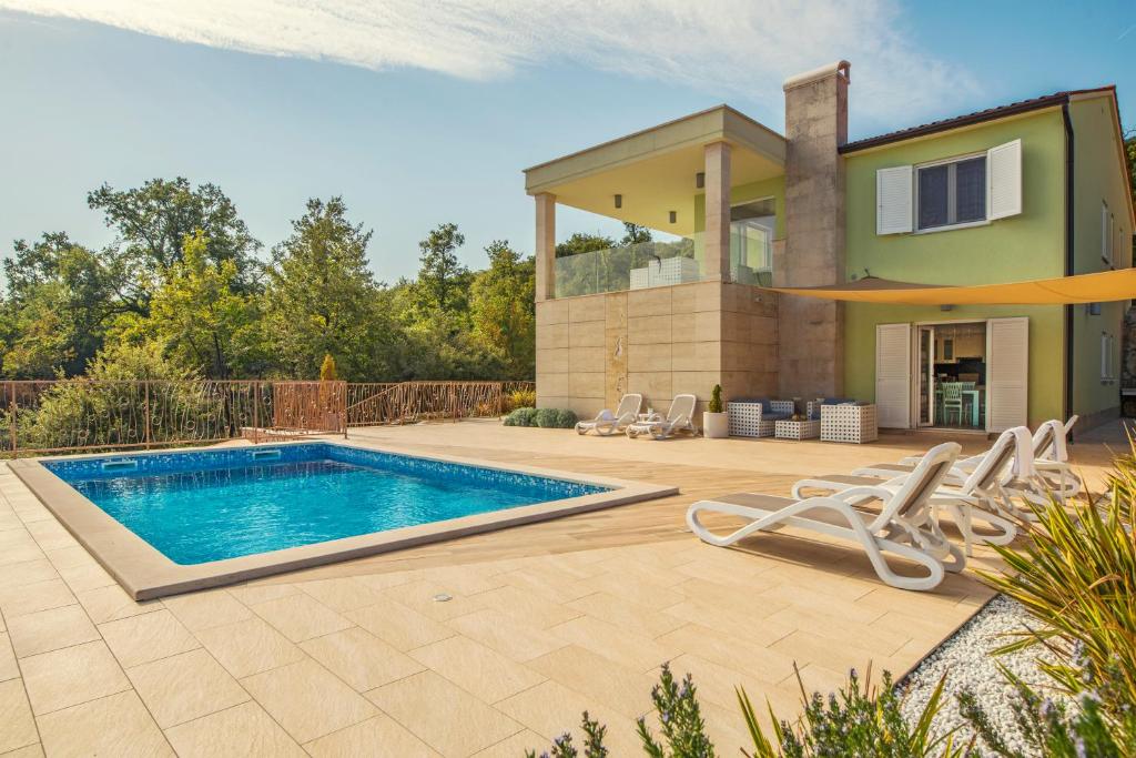 een villa met een zwembad en een huis bij Villa Luce in Labin