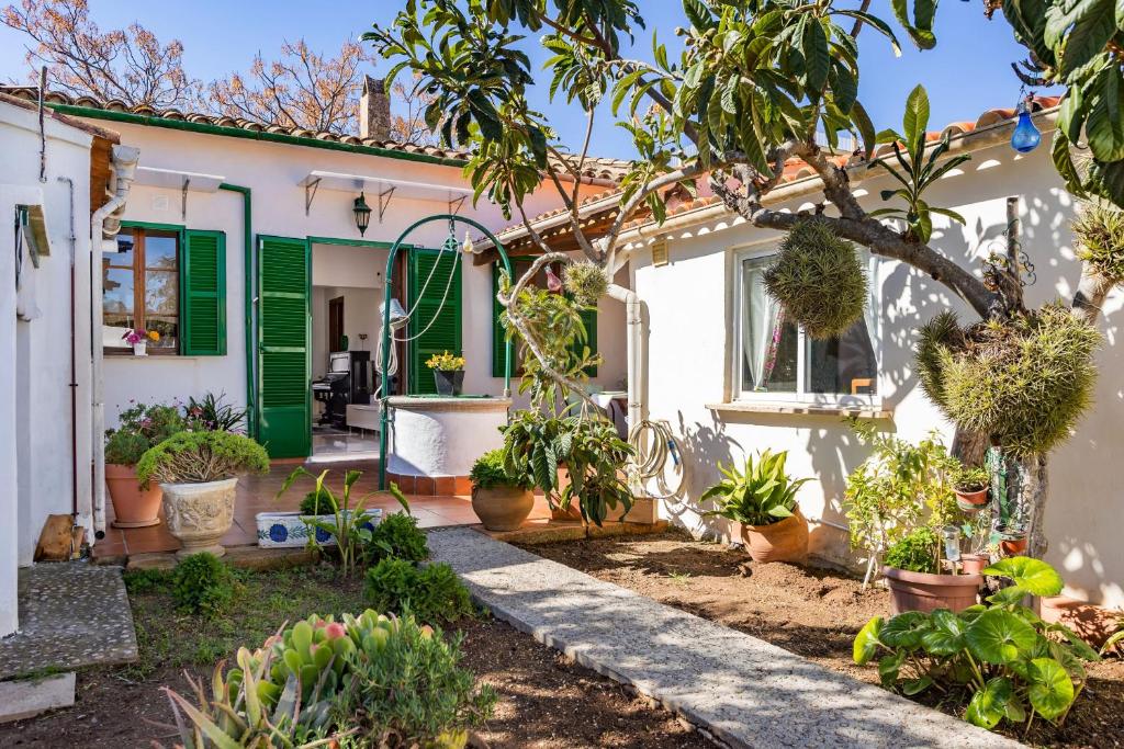 a house with green shutters and plants in the yard at Casa Vileta in Palma de Mallorca