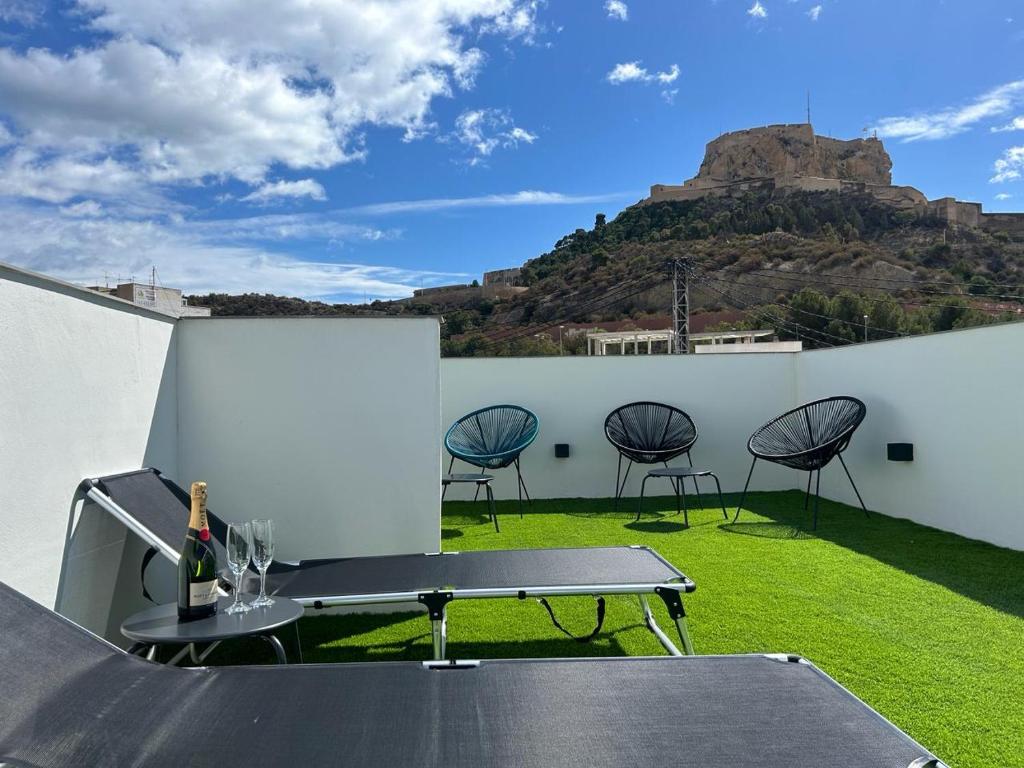 a table and chairs with a mountain in the background at Apart-hotel Happy Life in Alicante