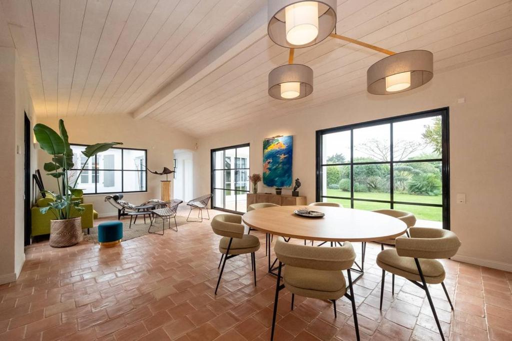 une salle à manger avec une table et des chaises dans l'établissement Maison galerie dans un jardin de 1200m2, au Bois-Plage-en-Ré