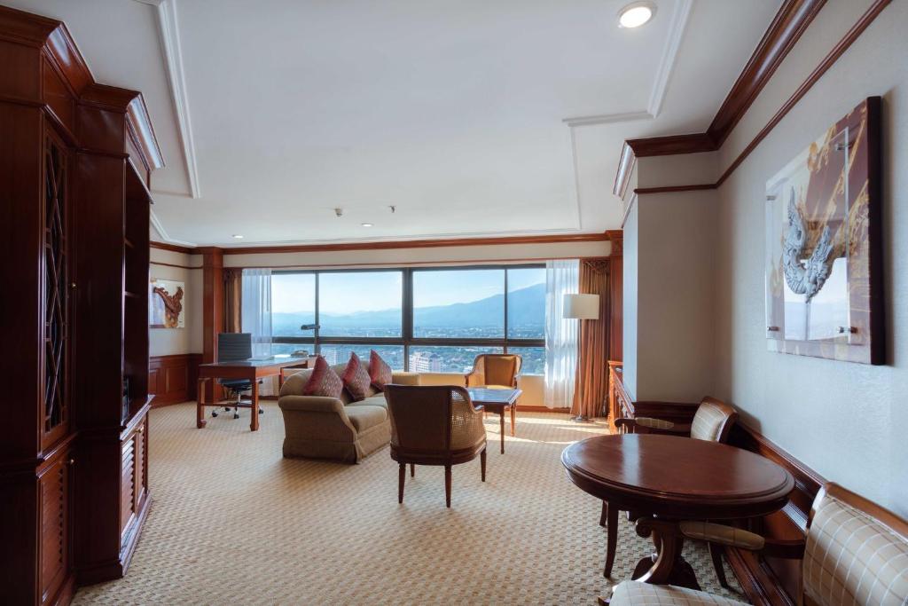 A large sitting room opens toward a mountain-and-city panorama through a wide window wall.