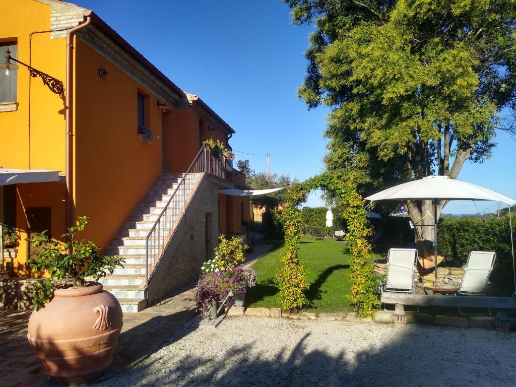 un jardín con mesa y sombrilla en Casa la Concia, en Potenza Picena