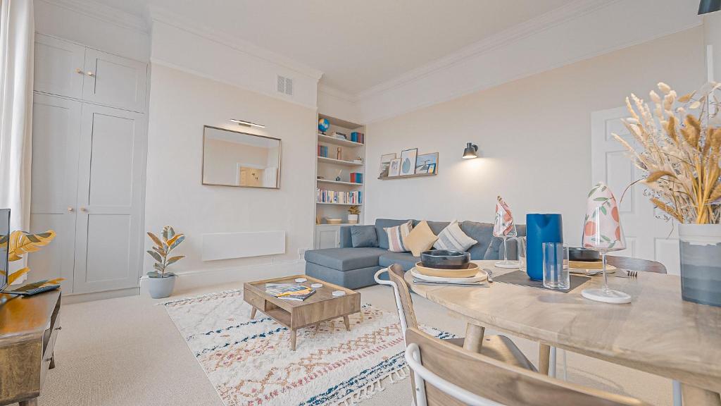 a living room with a table and a blue couch at Burlington Mansions - Stunning Coastal Apartment in Bournemouth