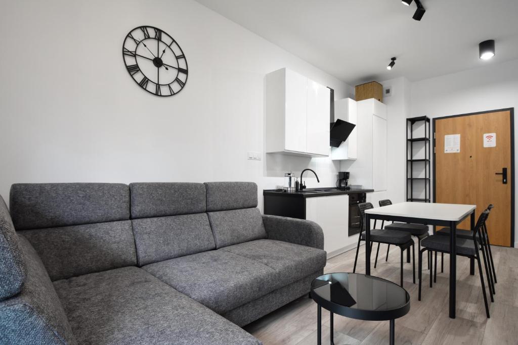 a living room with a couch and a table and a kitchen at RentPlanet - Apartament Bałtycka II in Kołobrzeg