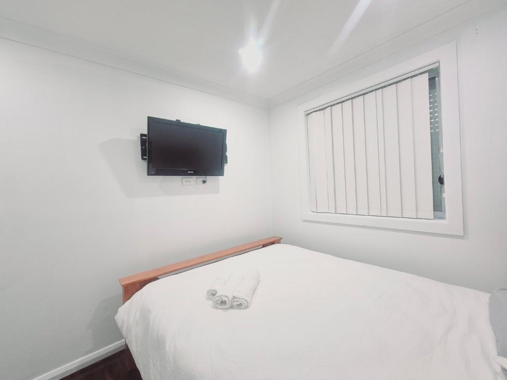 a bedroom with a bed and a tv on the wall at Kaban Power 39 in Bidwill