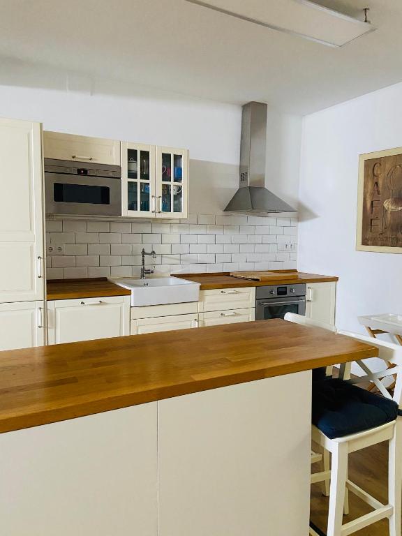Una cocina con gabinetes blancos y una encimera de madera. en VILLA FALI, en Benaguacil