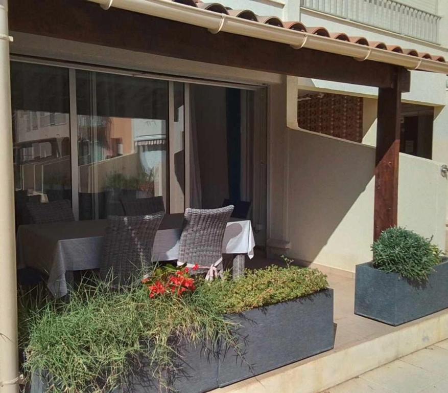 une terrasse avec une table et des chaises dans une maison dans l'établissement Grand T3 piscine, garage centre port, au Cap d'Agde
