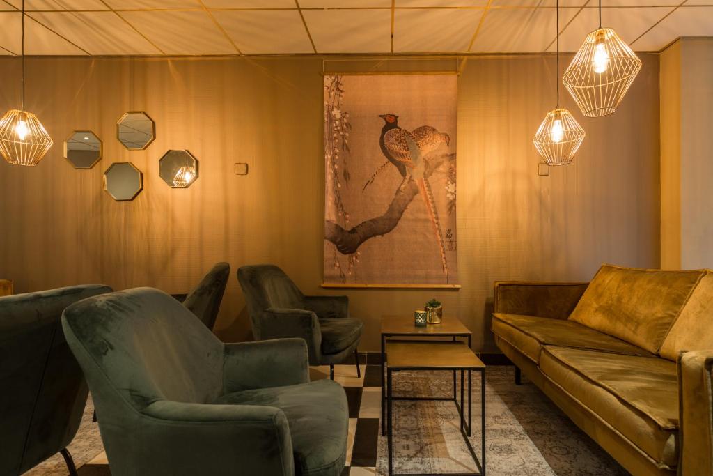 ein Wohnzimmer mit einem Sofa und Stühlen in der Unterkunft New West Inn Amsterdam in Amsterdam